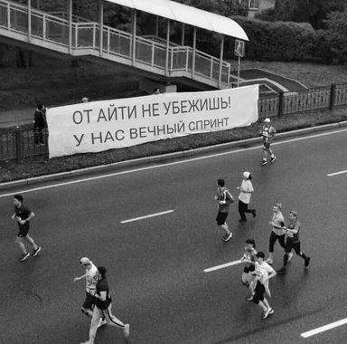 a black and white photo of people running on a road with a large banner that reads 'you can't escape IT, we have a never-ending sprint'