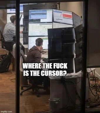Man sitting at computer with multiple monitors looking frustrated