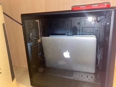 Apple laptop awkwardly fitted inside a computer tower