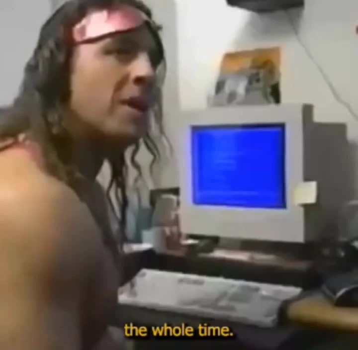 man sitting at computer with blue screen and surprised expression