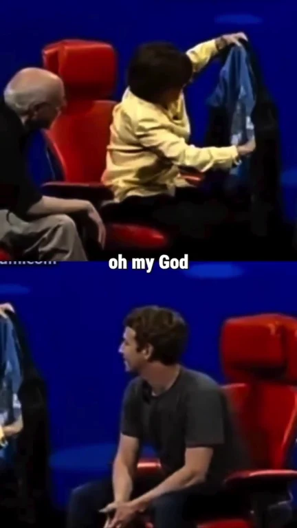 Elon Musk sitting in a red chair looking shocked and saying 'oh my God'.