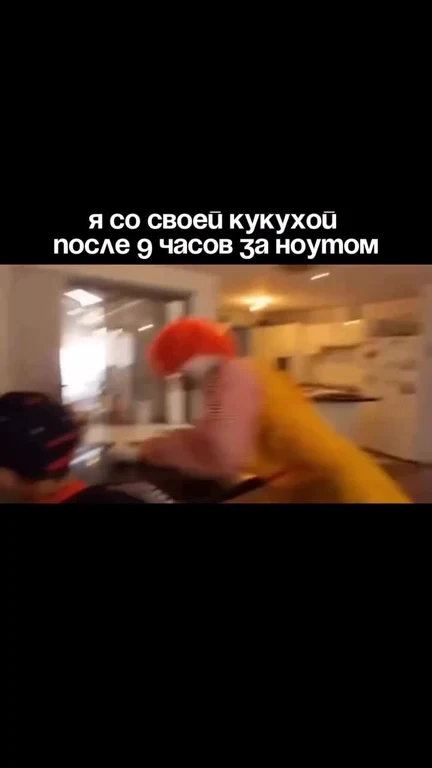 blurry video thumbnail of a person in a yellow shirt and orange hair, sitting at a desk with a laptop