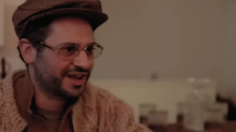 man in brown hat and glasses looking to the side with a surprised expression