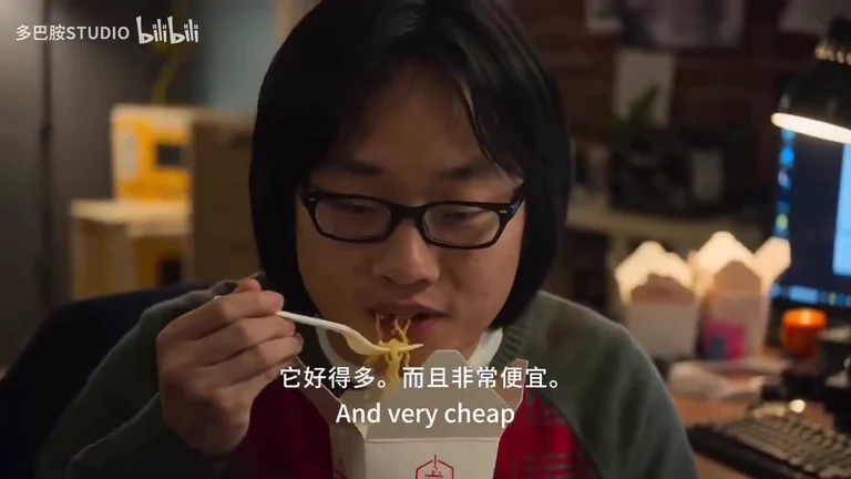 Developer eating instant noodles at a computer desk