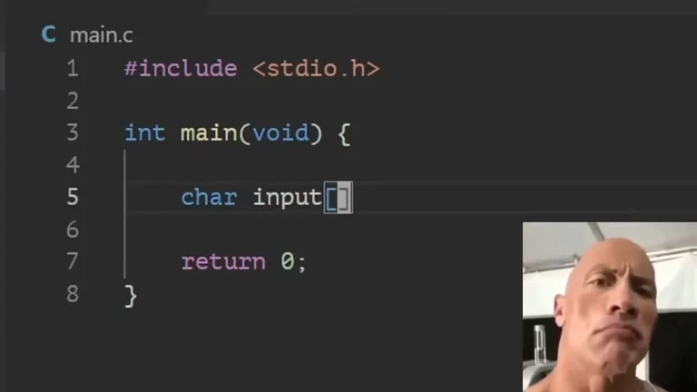 bald man looking confused in front of a computer screen with C code