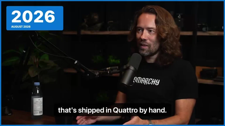 Man in a podcast studio with a 2026 date stamp and caption 'that's shipped in Quattro by hand'
