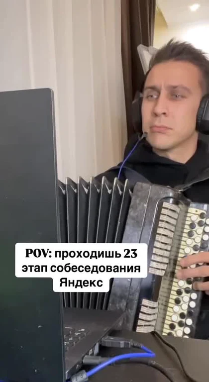 Man playing accordion in front of computer screen