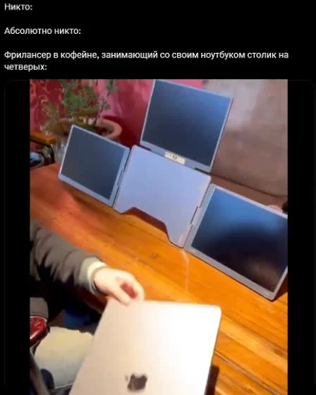 a person sitting at a table with multiple laptops