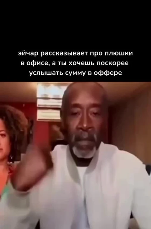 Кадр из видео: мужчина в белой куртке рядом с женщиной, подпись про HR, который рассказывает про офисные плюшки, пока