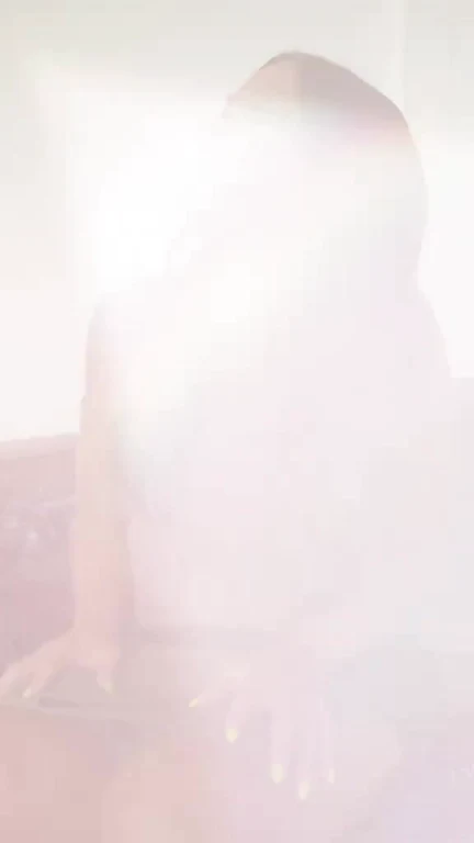 A person sitting at a desk with hands on a keyboard, obscured by a massive white light leak from the screen.