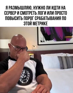 Задумчивый мускулистый мужчина в очках прикрывает рот кулаком в гостиничном номере — мем про on-call: идти на сервер