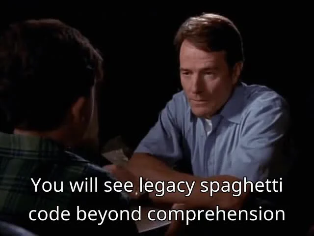 Two men sitting at a table with text overlay: 'You will see legacy spaghetti code beyond comprehension'