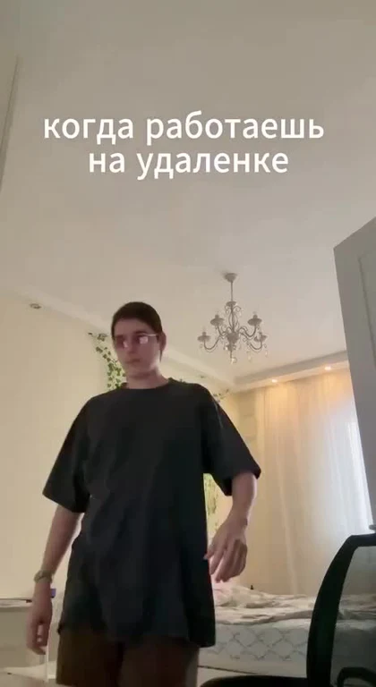 a man in a black shirt standing in a bedroom with a caption about working remotely