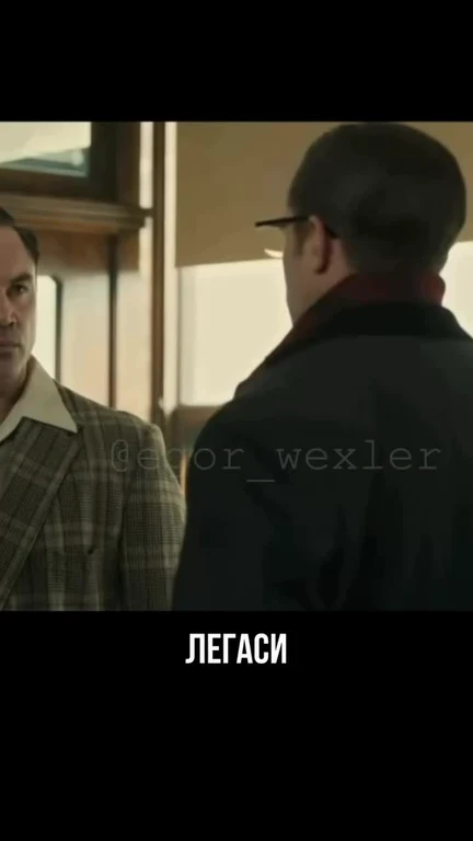 Two men in suits looking at each other, with Russian text at the bottom.