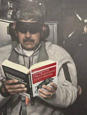 Man wearing headphones and reading two books on data applications