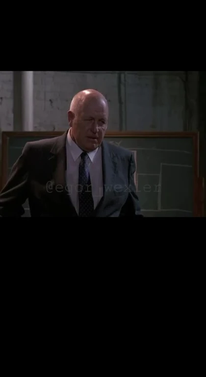 Bald man in a suit with a disapproving expression