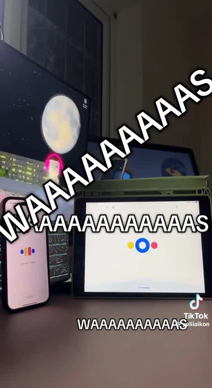 A desk with a phone, tablet, and computer monitor all displaying the loading animation for the AI assistant Claude.