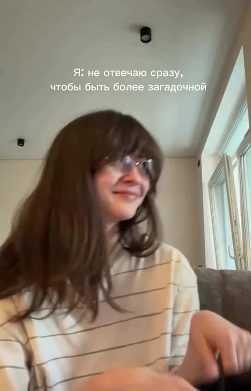 A girl smiling and typing on a keyboard with text about not answering immediately to seem mysterious.