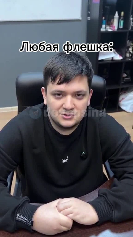 Man in black sweatshirt with a serious expression and Russian caption
