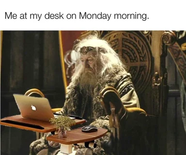 Gandalf sitting at a desk with a laptop looking tired