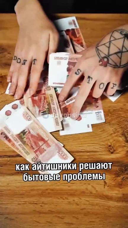 Hands with 'don't stop' tattoos on fingers, surrounded by Russian banknotes on a wooden table