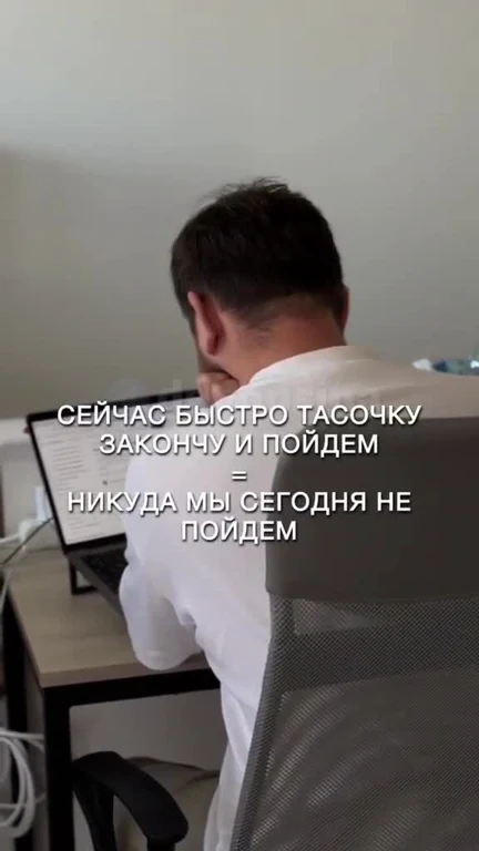 Man sitting at desk with laptop, looking away with Russian text overlay
