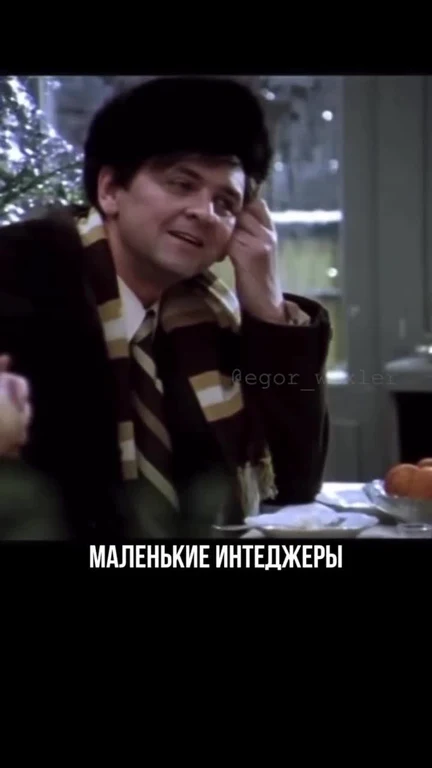 man in brown coat and scarf laughing on phone with text маленькие интЕджеры