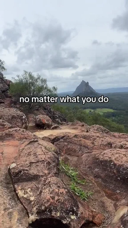 A landscape view of a rocky cliffside and a distant mountain with the text overlay 'no matter what you do'.