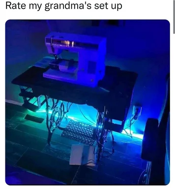 a sewing machine on a table with blue lights and a keyboard underneath
