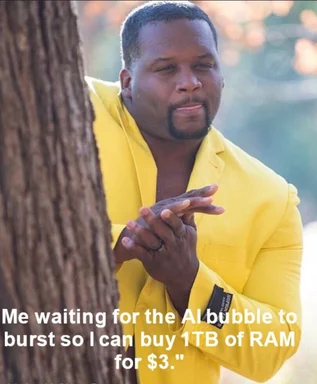 Man in a yellow suit peeking from behind a tree with text: Me waiting for the AI bubble to burst so I can buy 1TB of RAM for $3.