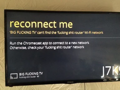 A TV screen displaying an error message about a 'fucking shit router' Wi-Fi network