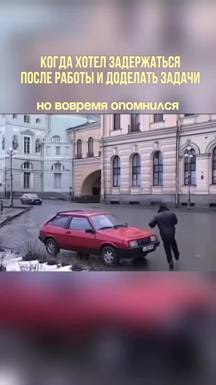 Man in dark clothes rushing to a red car parked on the side of a street with buildings in the background