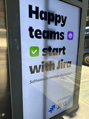 A close-up photo of an advertisement for Jira with a green checkmark.