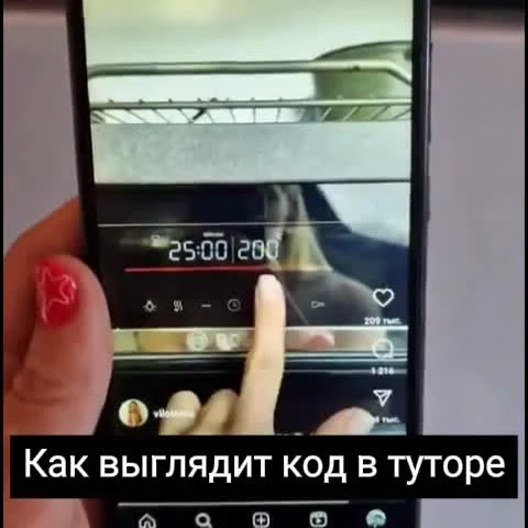 a hand holding a phone with a video player on the screen and a caption in russian