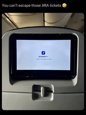 in-flight entertainment screen displaying jira logo with the caption 'You can't escape those JIRA tickets'
