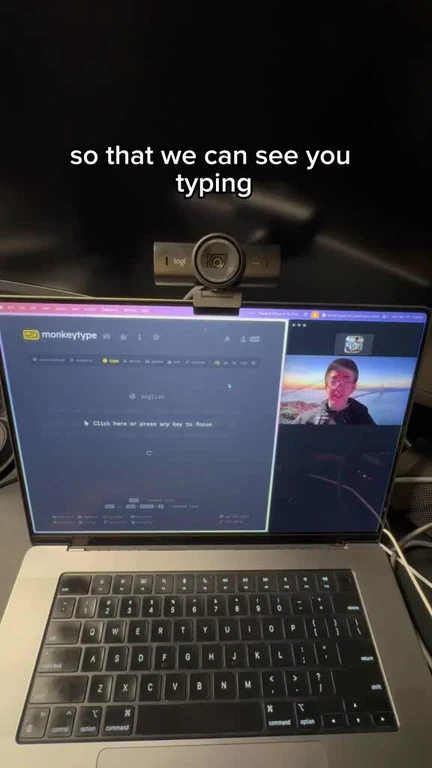 Laptop screen showing a video call with a man on the right and a typing test on the left, with a webcam above the screen and the text 'so that we can see you typing'