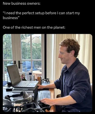 Mark Zuckerberg sitting at a desk with multiple devices