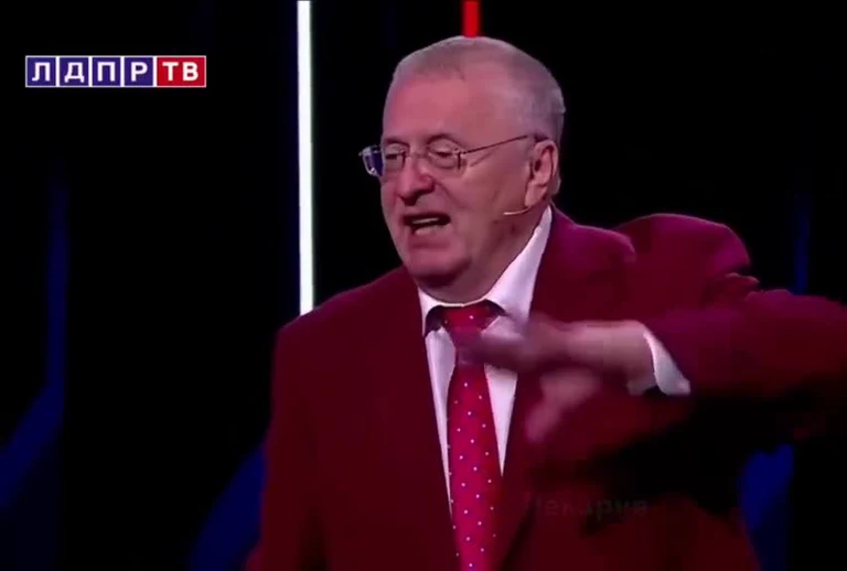 Russian TV host in red suit pointing