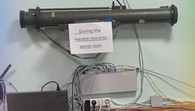 a server room with a sign that says 'During the evacuation, shoot at the server room'