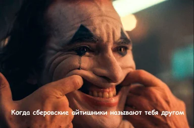 Joker smiling and touching his face with a creepy grin