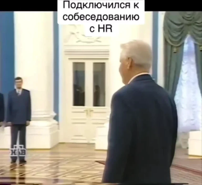 Man in suit looking at another man in suit with russian text about HR interview