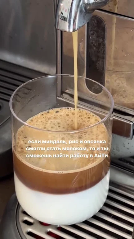 coffee machine pouring coffee into a glass with layers of milk and coffee