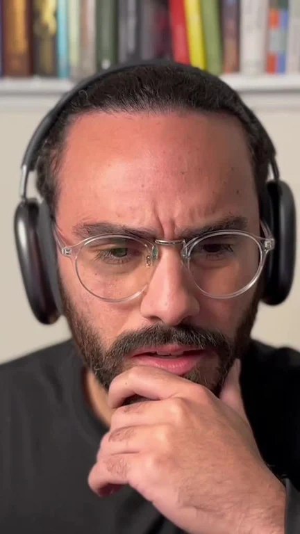 man in headphones and glasses looking thoughtful