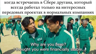 Two men in green tracksuits with white stripes and numbered patches talking to each other, with a group of people in similar outfits in the background.