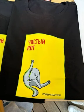 black t-shirt with yellow book cover design featuring a dancing cat and Russian text