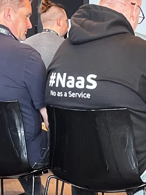 man wearing black hoodie with #Naas No as a Service text