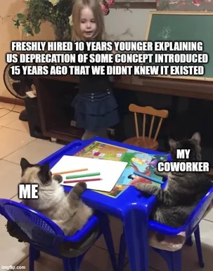 Two cats labeled 'Me' and 'My Coworker' sit at a small blue table while a young girl stands behind them, captioned as a