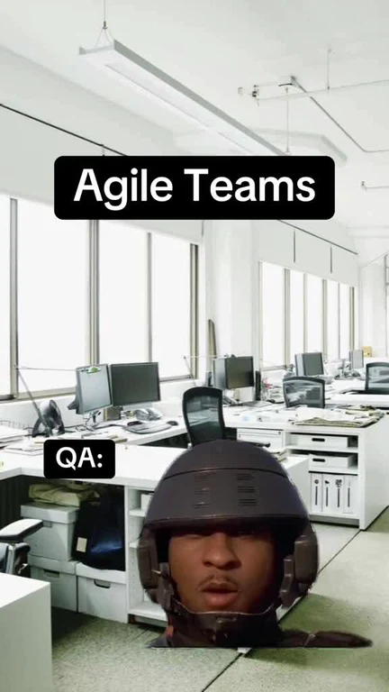 Man wearing a helmet in an office with computers and desks labeled 'Agile Teams' and 'QA:'