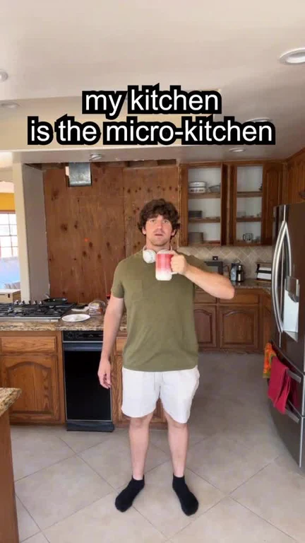 man in kitchen holding coffee mug with text 'my kitchen is the micro-kitchen'