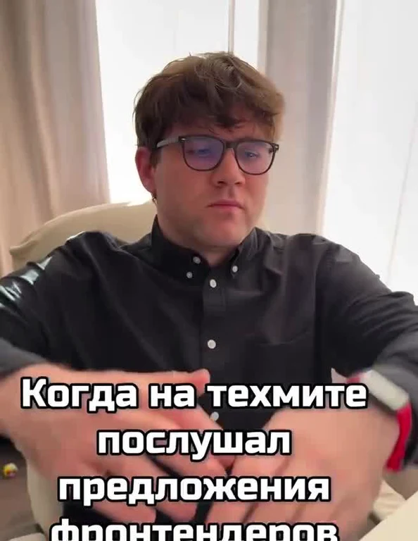 Man in glasses sitting in a chair with a skeptical expression